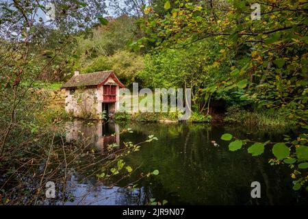 The Boat House im Herbst am Middle Pond auf dem Gelände des Woodchester Park, Gloucestershire, England Stockfoto