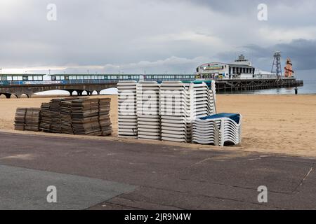 Liegestühle und Sonnenliegen liegen an der Promenade am Bournemouth Beach Stockfoto