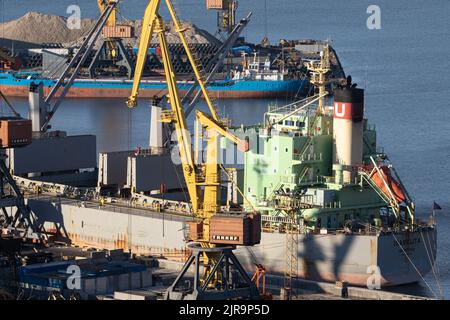 ODESSA, UKRAINE-27. NOVEMBER 2021: Odessa Handelshafen in Friedenszeiten 4 Monate vor Kriegsbeginn mit Russland. Schiffskräne, Lagerhäuser, Tanker Stockfoto