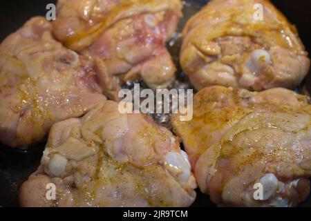 Heiße Hähnchenschenkel kochen in einer Küche mit Gewürzen. Stockfoto