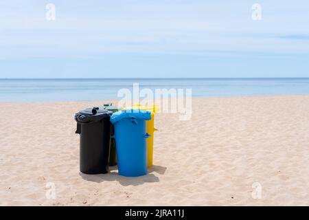 Saubere Mülltonnen am Strand. Mehrfarbige Müllcontainer für die getrennte Müllabfuhr stehen an leeren Stränden in der Nähe des Ozeans Stockfoto