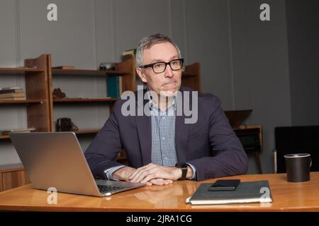 Nachdenkliche zweifelhafte Geschäftsmann in Spannung denken machen schwierige Entscheidung bei der Arbeit, betonte Mann reflektiert besorgt über Problem Herausforderung sitzen an Stockfoto