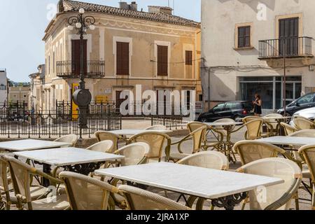 Arta, Spanien; 13 2022. august: Nahaufnahme der Tische in einem leeren Restaurant. Im Hintergrund der metallische Brunnen im Wasserquadrat, der sich im M befindet Stockfoto