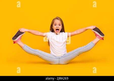 In voller Länge Foto von funky ziemlich Schulmädchen gekleidet weißen T-Shirt sitzend Boden gespalten Beine isoliert gelben Hintergrund Stockfoto