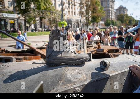 Stiefel eines russischen Soldaten auf einem gepanzerten Personallaufer. Ein Fragment eines rostigen ausgebrannten Autos Russlands. Ausstellung der zerstörten verbrannten russischen Militärausrüstung auf Chreschatyk. Ukraine, Kiew - 21. August 2022. Stockfoto