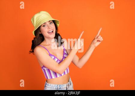 Foto von beeindruckt Brünette Dame Index Förderung tragen Kappe violett oben isoliert auf orange Farbe Hintergrund Stockfoto