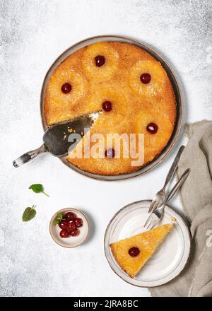 Stück umgedrehter Ananaskuchen mit kandierten Kirschen und Karamell. Hausgemachtes tropisches Dessert im Sommer. Draufsicht. Stockfoto