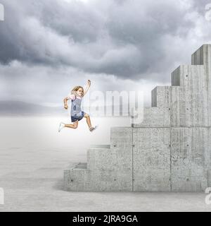 Mädchen rennt, um eine lange Betontreppe zu erklimmen Stockfoto
