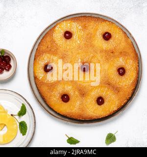 Hausgemachte Ananas auf den Kopf gestellt Kuchen mit Glace Kirschen. Köstliches vegetarisches Süßspeisen-Konzept. Quadratisches Bild. Stockfoto