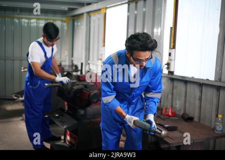 Arbeiter wechseln und reparieren Teile der Räder beim Autoservice Stockfoto