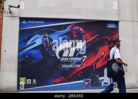 London, Großbritannien. 23.. August 2022. Ein Mann kommt an einer Werbung für Gran Turismo 7 vor dem britischen Sony PlayStation-Büro in Soho vorbei. Sony wurde für £5 Milliarden angeklagt, weil es angeblich „seine Dominanz missbraucht“ und Kunden auf dem britischen Markt überfordert hat. Kredit: Vuk Valcic/Alamy Live Nachrichten Stockfoto