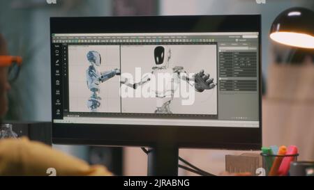 Afroamerikanischer Mann, der 3D Modell eines Roboters erstellt und Video für Film oder Computerspiel auf dem Computer rendert, während er von zu Hause aus arbeitet Stockfoto