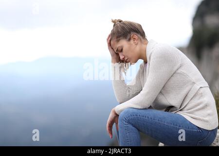 Seitenansicht Porträt einer traurigen Frau, die sich allein im Berg beklagt Stockfoto