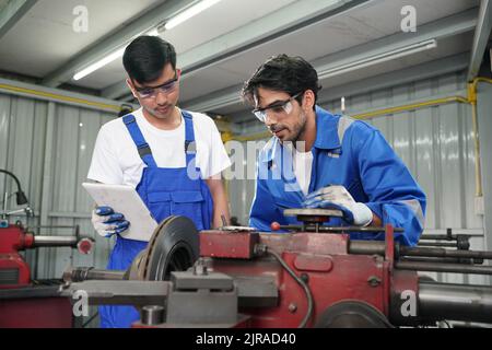 Arbeiter wechseln und reparieren Teile der Räder beim Autoservice Stockfoto