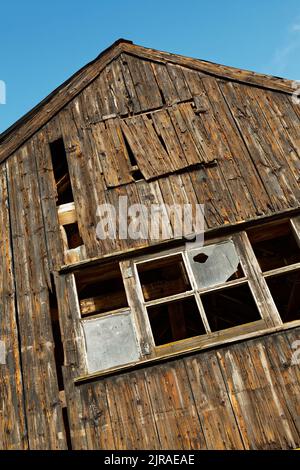 Altes, rustikales, heruntergekommenes Schuppen mit kaputten Fenstern. Stockfoto