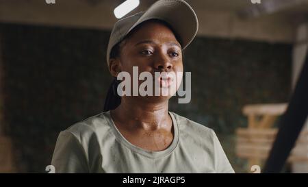 Afroamerikanische Soldatin atmet und hört männlichen Instruktor während der Pause in der Aussetzung Training in der Turnhalle der USA Militärbasis zu Stockfoto