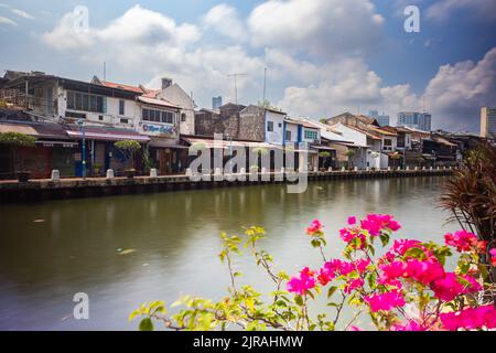 Malacca, Malaysia - 10. August 2022: Entlang des Flusses Melaka mit den alten, bunt bemalten Häusern. Bars und Restaurants säumen den Flusslauf. L Stockfoto