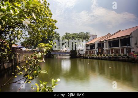 Malacca, Malaysia - 10. August 2022: Entlang des Flusses Melaka mit den alten, bunt bemalten Häusern. Bars und Restaurants säumen den Flusslauf. L Stockfoto