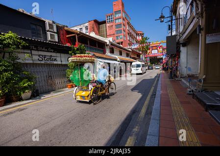 Malacca, Malaysia - 10. August 2022: Die Jonker Street im Zentrum von Melaka. Einer der bekannten bunt dekorierten und ziemlich lauten Rikschas, Stockfoto