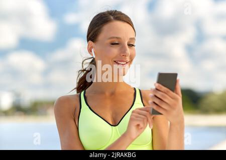 Frau mit Kopfhörern und Smartphone Sport Stockfoto