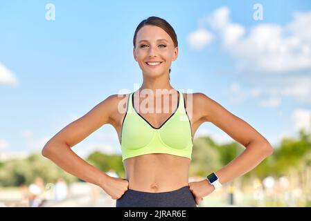 Porträt einer lächelnden jungen sportlichen Frau im Freien Stockfoto