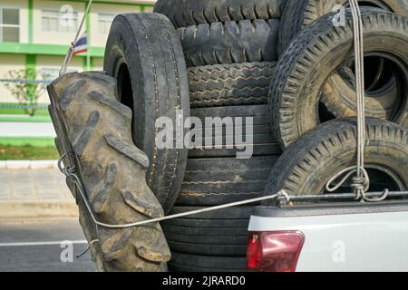 Ein überlasteter Pickup-Truck, der gebrauchte Gummireifen zum Recycling mit sich führt und in Thailand aufgenommen wurde. Stockfoto