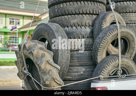 Ein überlasteter Pickup-Truck, der gebrauchte Gummireifen zum Recycling mit sich führt und in Thailand aufgenommen wurde. Stockfoto