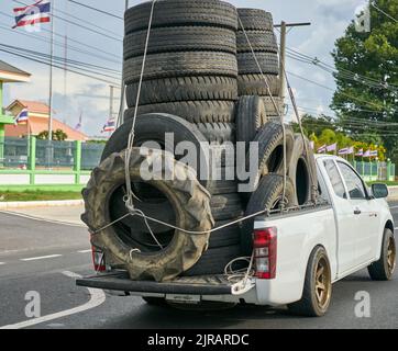 Ein überlasteter Pickup-Truck, der gebrauchte Gummireifen zum Recycling mit sich führt und in Thailand aufgenommen wurde. Stockfoto