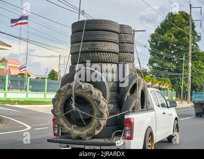 Ein überlasteter Pickup-Truck, der gebrauchte Gummireifen zum Recycling mit sich führt und in Thailand aufgenommen wurde. Stockfoto