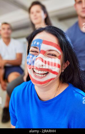 Glückliche Frau mit amerikanischer Flagge auf dem Gesicht gemalt Stockfoto