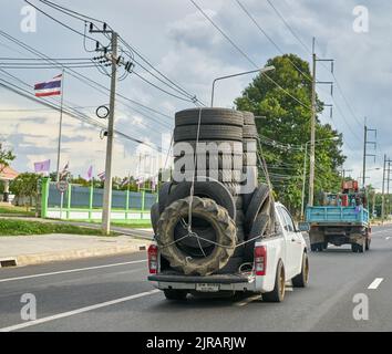 Ein überlasteter Pickup-Truck, der gebrauchte Gummireifen zum Recycling mit sich führt und in Thailand aufgenommen wurde. Stockfoto