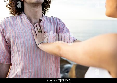 Freundin hält die Hand auf der Brust des Freundes Stockfoto