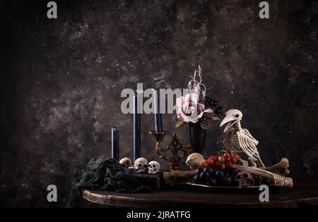 Halloween Stillleben mit Totenkopf, Knochen und Kuchen Stockfoto