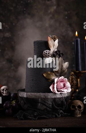 Halloween Stillleben mit Totenkopf, Knochen und Kuchen Stockfoto