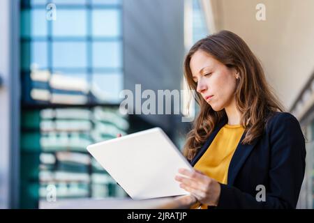 Geschäftsfrau mit braunem Haar mit Tablet-PC Stockfoto