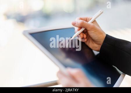 Hand einer Geschäftsfrau mit digitalisierter Stiftzeichnung auf einem Tablet-PC Stockfoto