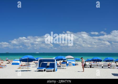 Miami Beach, USA - 18. März 2017 : Touristen auf Strandliegen und Sonnenschirmen in South Beach, Miami Beach am Atlantik. Stockfoto