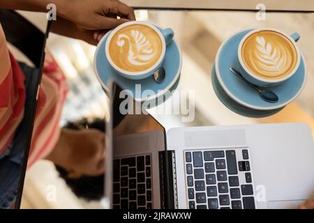Kellnerin serviert Cappuccino im Café Stockfoto