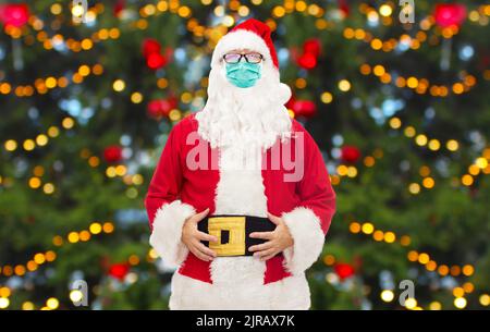 Mann im Kostüm des weihnachtsmannes in medizinischer Maske Stockfoto