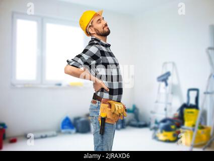 Männlicher Arbeiter oder Baumeister mit Rückenschmerzen Stockfoto