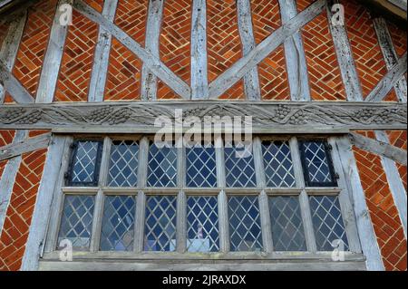 Unterhalb der 1500er Jahre mit Fischgrätenziegeln ziert eine Weinrebe, die regelmäßig Trauben aus Eichenholz trägt, tragende Balken im Nordgiebel der Tudor-Moot Hall in Aldeburgh, Suffolk, England, Großbritannien. Die Halle wurde um 1520 unter König Heinrich VIII. Erbaut und 1654 umgebaut. Ursprünglich ein offener Markt, ist das Gebäude heute das Rathaus und beherbergt das Aldeburgh Museum. Die Moot Hall ist seit 400 Jahren das Zentrum der lokalen Regierung in Aldeburgh. Stockfoto