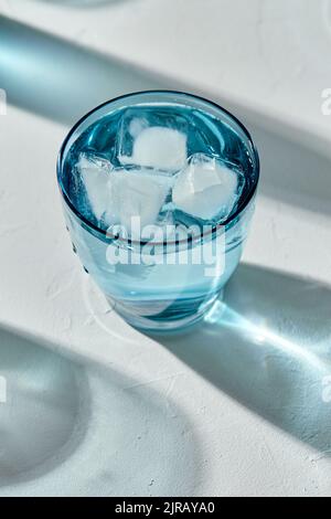 Blaues Glas kaltes Wasser mit Eiswürfeln Stockfoto