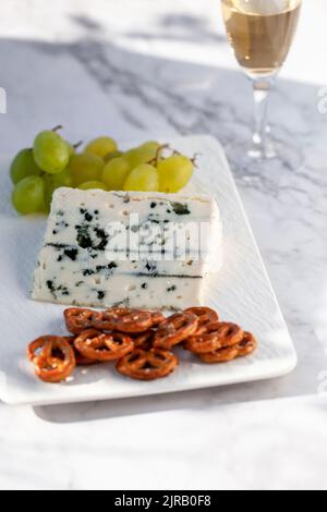 roquefort Käse serviert mit grünen Trauben und Snacks im Freien, hartes Licht Stockfoto