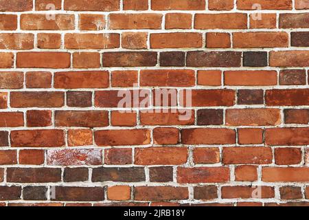 Vorderansicht der alten schmutzigen roten Ziegelwand Stockfoto