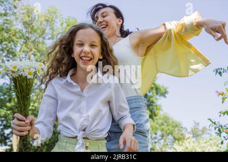 Glückliche Mutter und Tochter tanzen im Park Stockfoto