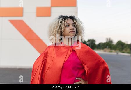 Nachdenkliche Frau mit blonden Haaren und Umhang Stockfoto