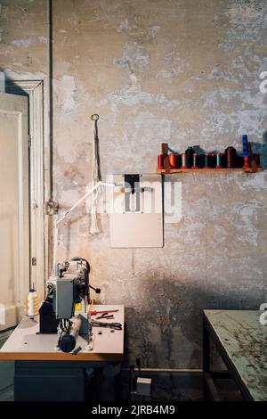 Nähmaschine vor der Wandwerkstatt Stockfoto