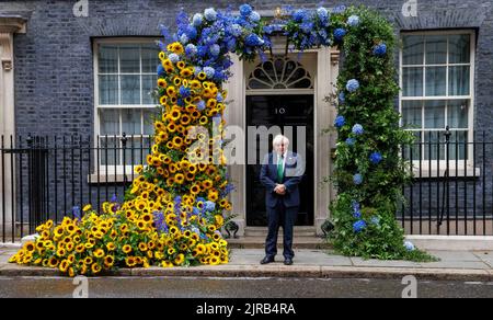 London, Großbritannien. 23. August 2022. AM 23.. AUGUST 9pm MIT EINEM BLUMENSCHMUCK posiert Boris Johnson vor der Tür der Nummer 10 zum Gedenken an den Unabhängigkeitstag in der Ukraine, der am 24.. August stattfindet. Kredit: Mark Thomas/Alamy Live Nachrichten Stockfoto