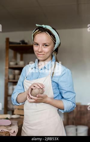Lächelnder Handwerker mit Lehm im Kunststudio Stockfoto