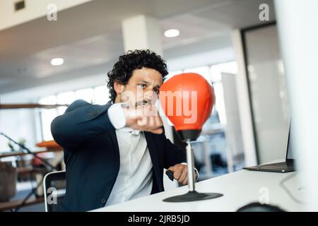 Engagierter Geschäftsmann Boxsack im Büro Stockfoto